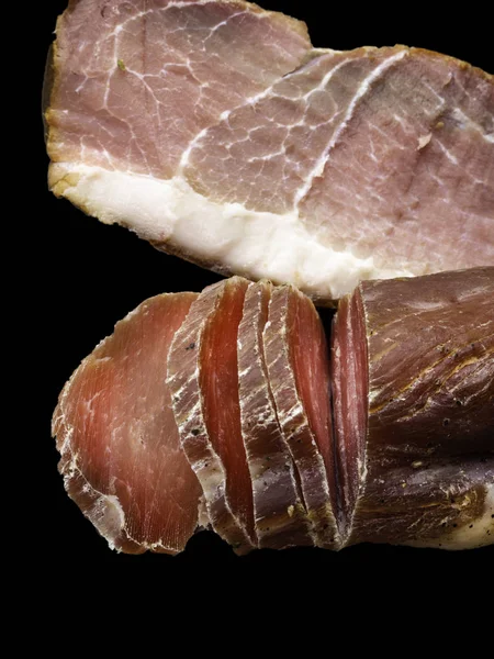 スペインのジャモン イベリコのジャーク肉と乾燥したハムを黒で分離 — ストック写真
