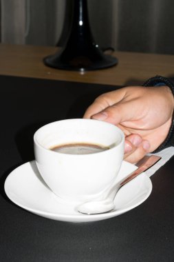 Kahve zamanı. Adamın elini sabah kafede kahve veya kahve Kupası tutun. Bir fincan kahve. Cappuccino ve siyah espresso kahve Kupası. Kahve içecek. Sıcak kahve kupaları tutan bir adam elinde yakın çekim.