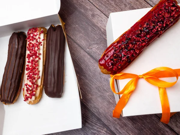 eclairs in a white box, delivery of eclairs, glazed eclairs, photos of eclairs close-up