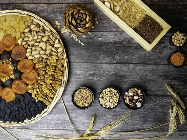 Health food background border with dried apricot, grains, pulses, seeds, nuts Food high in antioxidants, smart carbohydrates, vitamins and minerals.