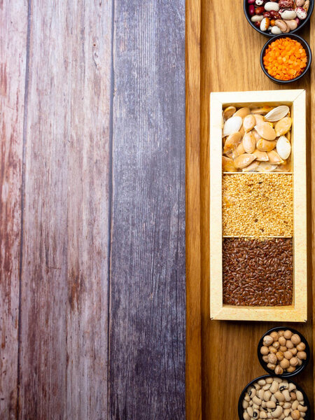 Различные виды семян бобов, чечевица, горох в блюде на деревянном столе, макробиотическая пища или здоровая пища, копировальное пространство
