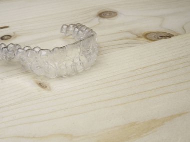 Inivisalign diş telleri. Ahşap yüzey üzerinde görünmez aligner