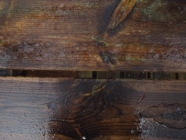 ıslak koyu ahşap yüzeye yansıması ile yağmur yağıyor