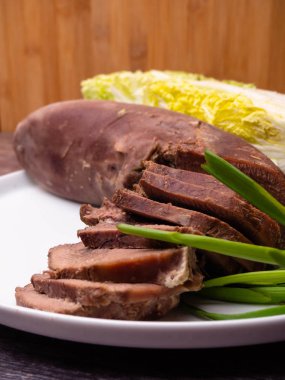 domuz eti veya sığır eti dilimleri Çin lahanası, beyaz plaka üzerinde yeşil soğan ile dil