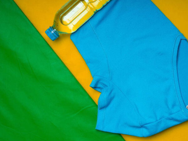 sport t-shirt and bottle of water on green mat, motivation concept
