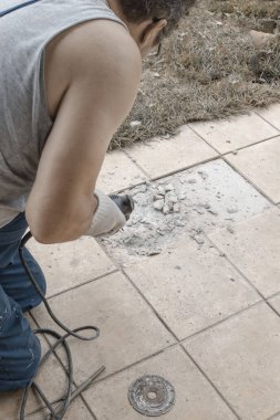 çalışan adam, eski yıkım ile perforator döşer. Eski zemin yenileme