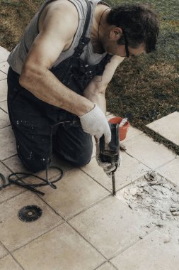 çalışan adam, eski yıkım ile perforator döşer. Eski zemin yenileme