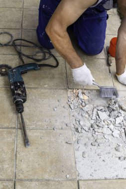 Erkek işçi çıkarma, perforator verandada, seçici odak ile fayans matkap