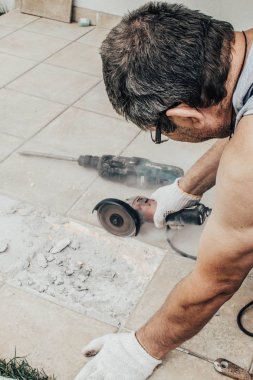 Daire testere. Alt Döşeme kesme. Kiremitli iş. İş karşı karşıya. Terbiye için aracı iş. Daire testere. Bir adam bir daire testere seçici odak İnşaat