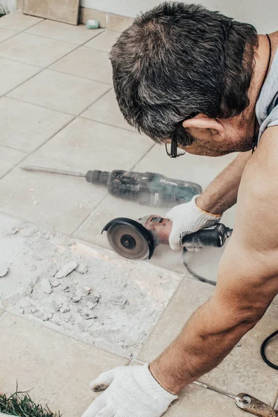 Daire testere. Alt Döşeme kesme. Kiremitli iş. İş karşı karşıya. Terbiye için aracı iş. Daire testere. Bir adam bir daire testere seçici odak İnşaat