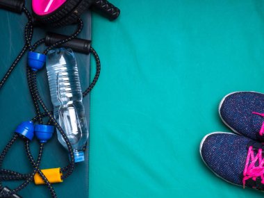 spor ayakkabı, halter, basın rulo, genişletici, şişe su yeşil arka plan üzerinde motivasyon kavramı belirleme