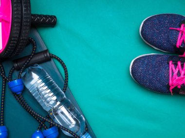 spor ayakkabı, halter, basın rulo, genişletici, şişe su yeşil arka plan üzerinde motivasyon kavramı belirleme