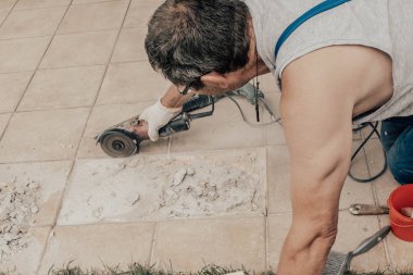 Daire testere. Seramik kesme bir adam. Çalışan bir döşeme üzerinde bir daire testere gördüm. İnşaat işleri. Seçici odak