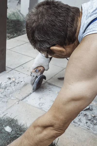 man cut angle grinder concrete in action Dust while grinding tiles