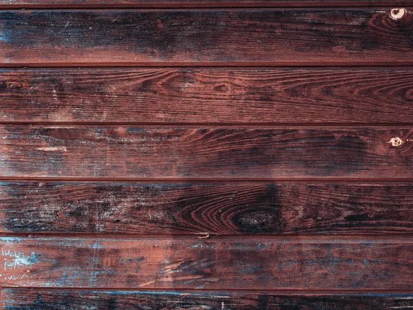 Old wooden barn board with distressed blue paint with shadows from sun