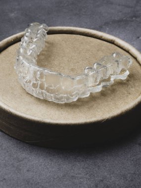 Diş aligners. Taş gri yüzey Parlatıcı görünmez parantez kavramı gülümse