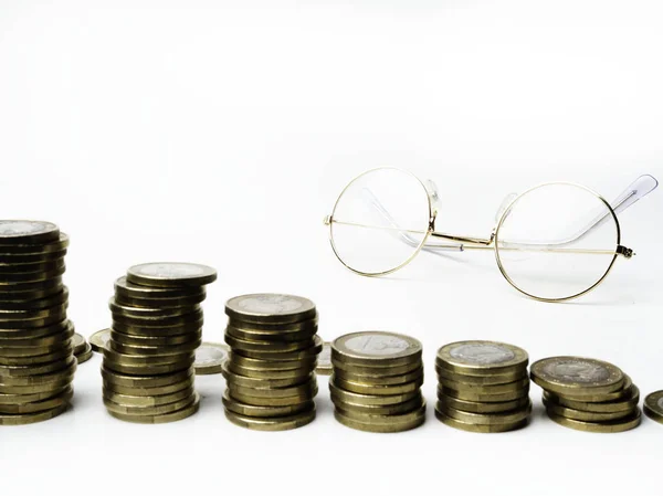 blurred Row of coins. Glasses on table, finance and banking concept, selective focus