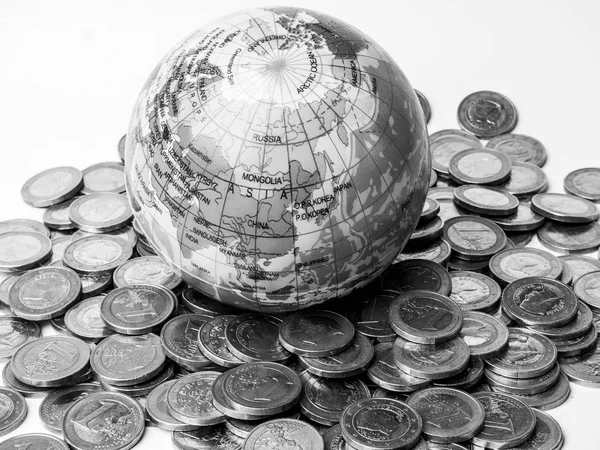 Pile of coins with world planet globe monochrome - Concept of saving the planet