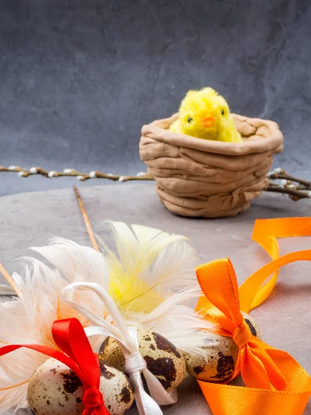 Little yellow toy chicken and Easter eggs tied in a bows with ribbon, copy space