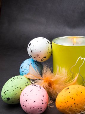 Paskalya dekorasyonu. Renkli yumurta ve tavşan ile yanan mum