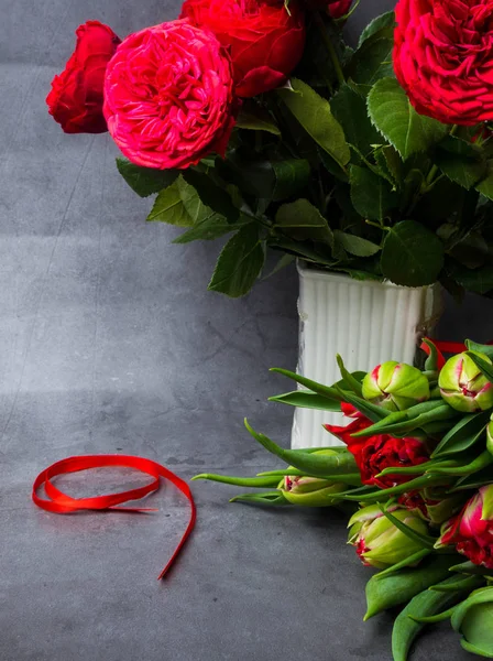Vörös tulipán és Rózsa piros szalaggal izolált beton háttérrel. A győzelem napja vagy a haza védője nap, 9 May szimbólum — Stock Fotó