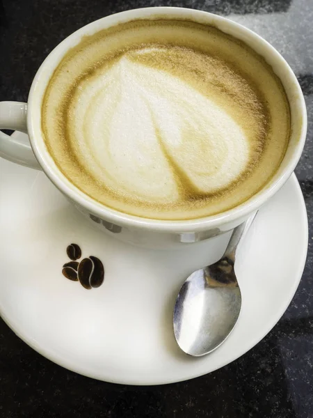 Taza de café con leche y granos de café aislados sobre fondo negro — Foto de Stock