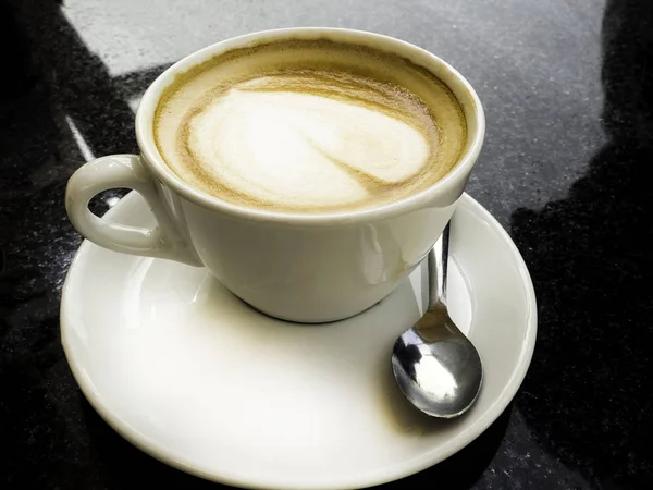 Taza de café con leche y granos de café aislados sobre fondo negro — Foto de Stock