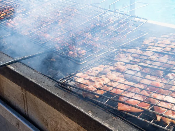 Gegrilde vlees barbecue op houtskool kachel met vol rook. Of brand houtskool in de kachel voor het koken van voedsel en barbecue. Zachte scherpstelling met stevige korrel — Stockfoto