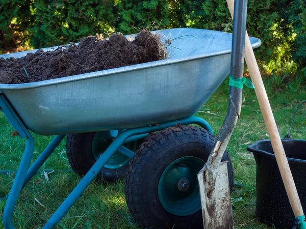 Pá, carrinho de mão na grama do jardim, com balde, conceito de jardinagem — Fotografia de Stock