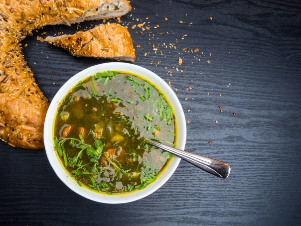 Sorrel quente e sopa de espinafre com pão de bagel no fundo de madeira . — Fotografia de Stock