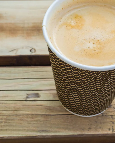Una taza de café para ir a la mesa de madera. Café de calle, vista superior . — Foto de Stock