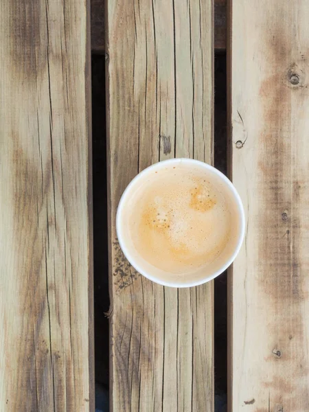 Una taza de café para ir a la mesa de madera. Café de calle, vista superior . — Foto de Stock