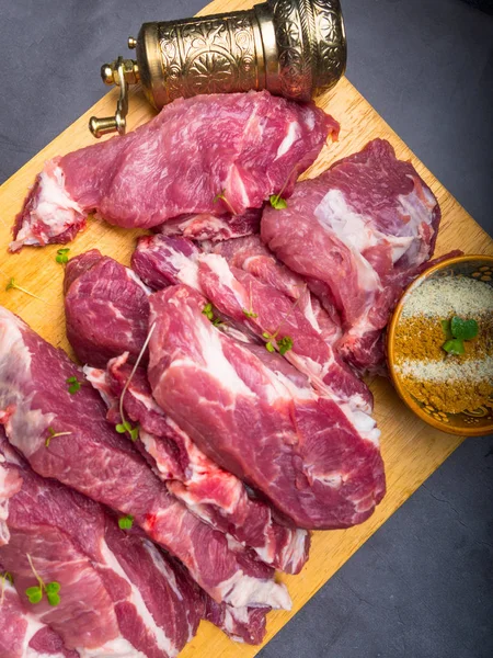 Fresh pork with ingredients for cooking on dark background — Stock Photo, Image