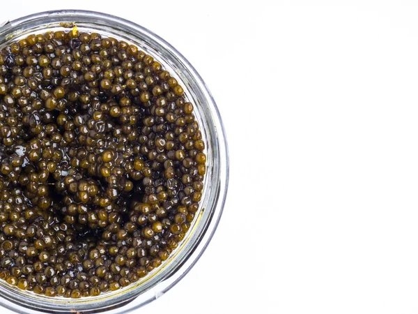 Caviar preto em um fundo branco em um frasco de vidro — Fotografia de Stock