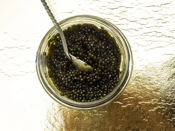 Caviar preto, delicadeza luxuosa em fundo dourado — Fotografia de Stock