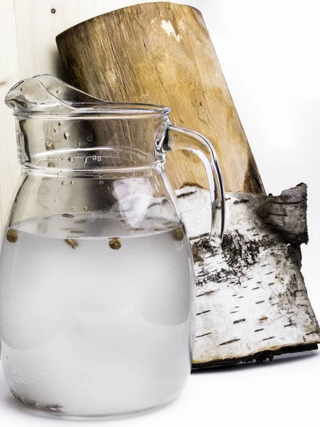 Spring useful vitamin drink. Fresh cold birch juice in a jug with raisins Concept of healthy and vitamin food