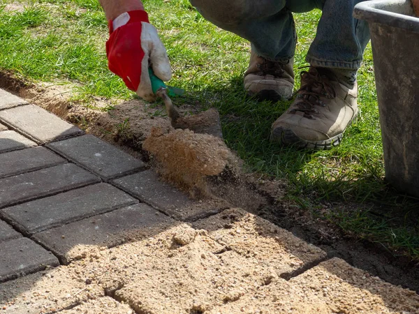 Colocación de losas de pavimentación de hormigón gris en patio de la casa patio de entrada. Trabajador profesional —  Fotos de Stock