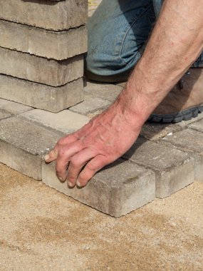 Ev avludrive veranda gri beton döşeme levhalar döşeme. Profesyonel işçi tuğlacı, kaldırım veya veranda tesviye kum temel tabanında.