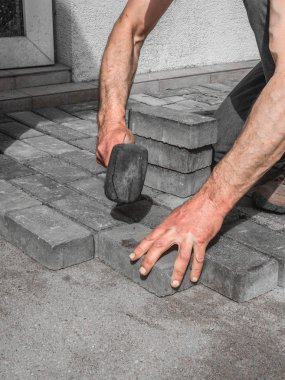 bir işçi kırmızı beton blok parke döşeme.