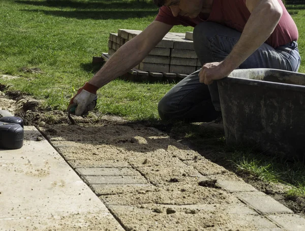 Posa lastre di cemento grigio pavimentazione in cortile patio casa vialetto. Operaio professionista — Foto Stock