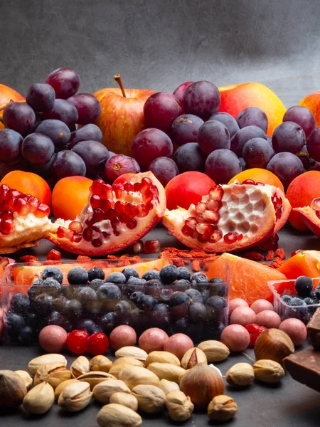 Composição com frutas sortidas nozes mirtilo, cranberry, amoreira e vinho tinto com chocolate, resvsratrol, alimentos ricos em antioxidantes — Fotografia de Stock
