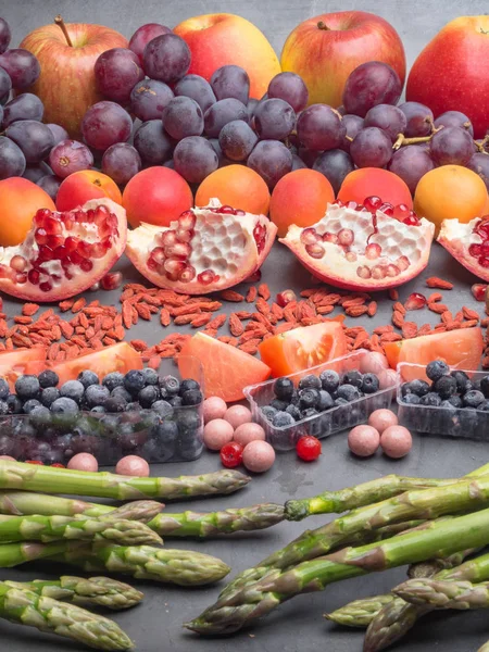 Comida saudável. Comida frutas diferentes, espargos, baga no fundo de concreto . — Fotografia de Stock