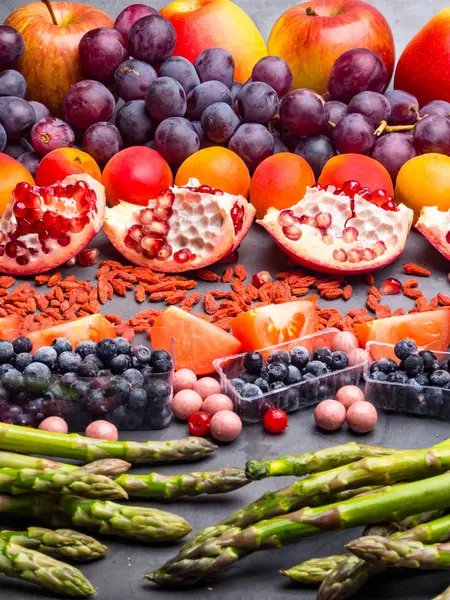 Comida saudável. Comida frutas diferentes, espargos, baga no fundo de concreto . — Fotografia de Stock