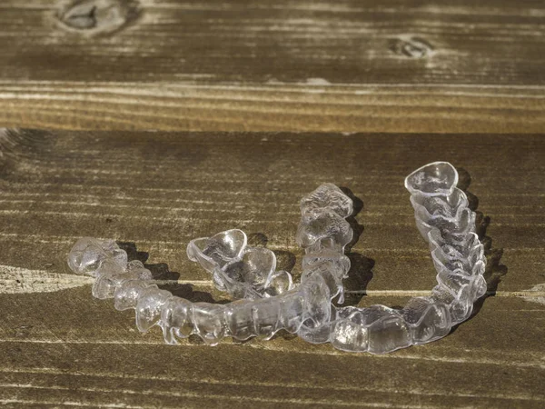 Transparent dental retainer or clear retainer, braces. Invisible aligner on the table wooden — Stock Photo, Image