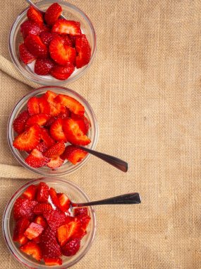 Glass bowls of strawberries with whipped cream. Traditional summer dessert