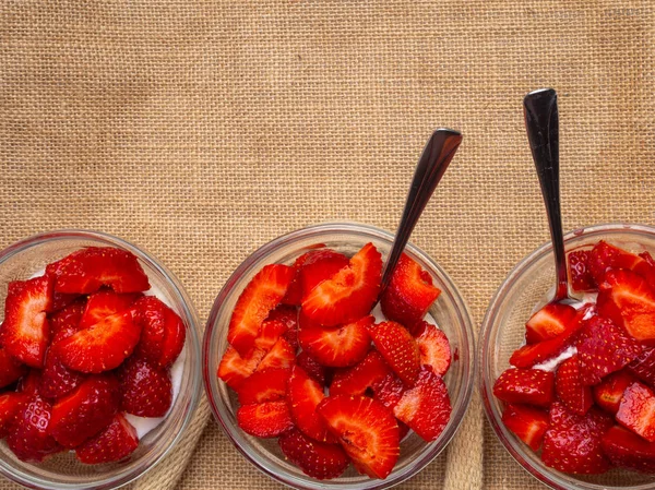 Glass bowls of strawberries with whipped cream. Traditional summer dessert — Stock Photo, Image