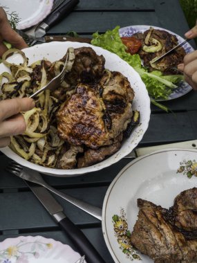 İnsanlar el açık barbekü bahçe parti toplama, seçici odak sağlıklı taze salata ve barbekü et yeme, bıçak ile BBQ kesti