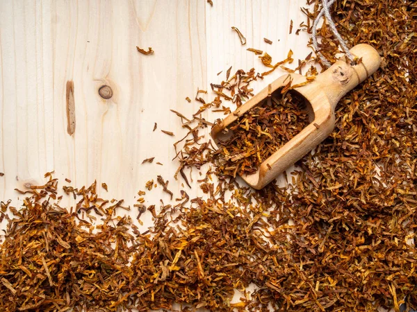 Ξερά φύλλα καπνών σε ξύλινη σανίδα και σε κουτάλι ξύλου — Φωτογραφία Αρχείου