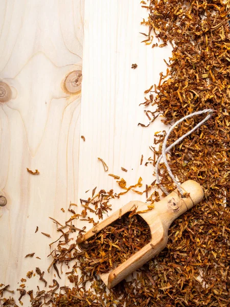 Ahşap tahta ve ahşap kaşık kuru tütün yaprakların — Stok fotoğraf