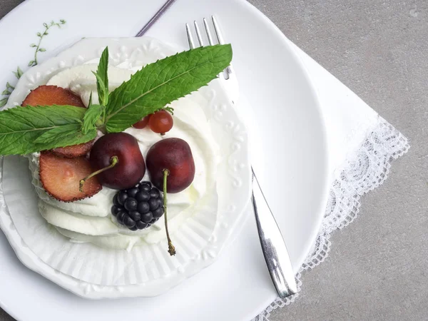 Tarta de merengue Pavlova con bayas frescas en plato blanco — Foto de Stock